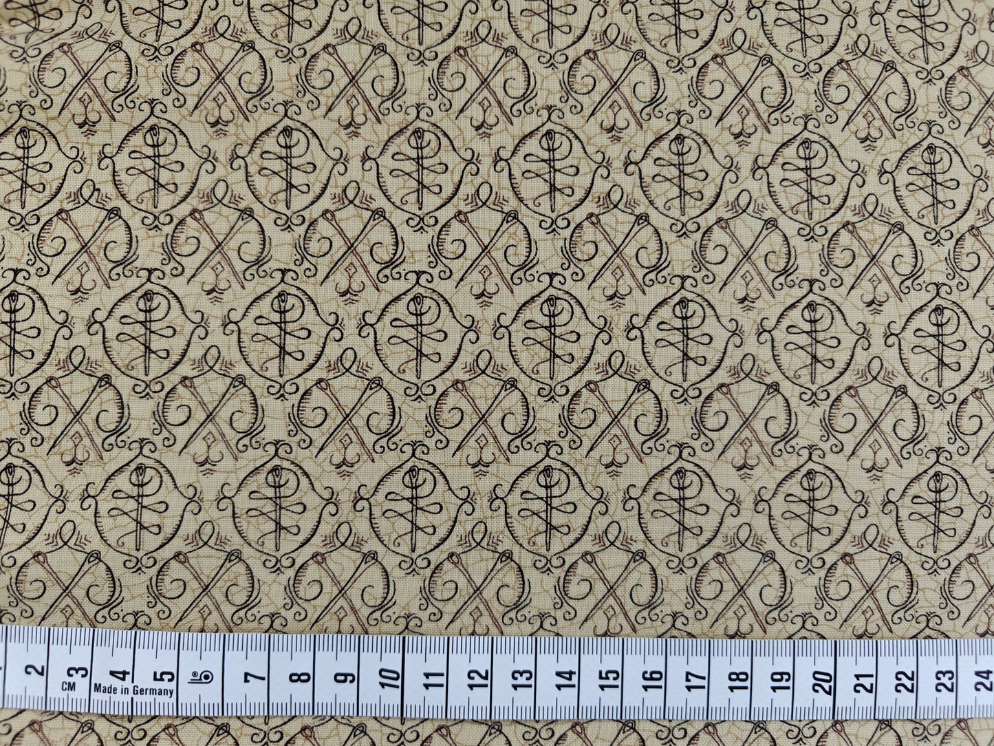 Piecemakers - Needle and thread on beige background